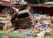 Sungguh Memprihatinkan Sebuah Mobil Minibus APV Terjerembab Diantara Tumpukan Sampah Dipasar Aek Nabara…!!